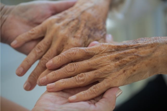 高齢者の手を支える人