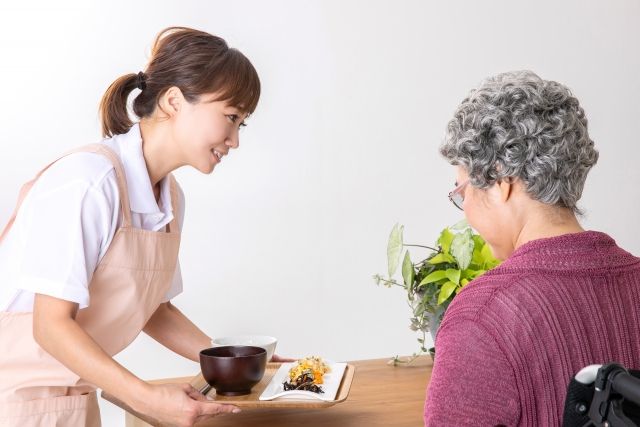 二本松市の介護施設で高齢者に食事の配膳を行う介護士